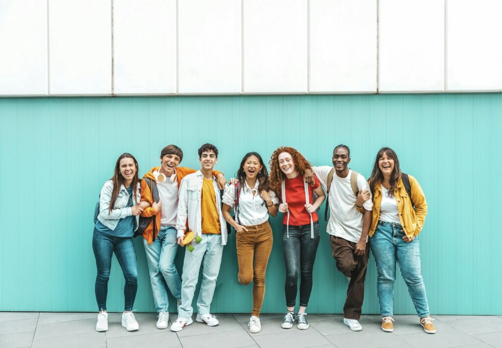 Diverse college students standing together on a blue wall