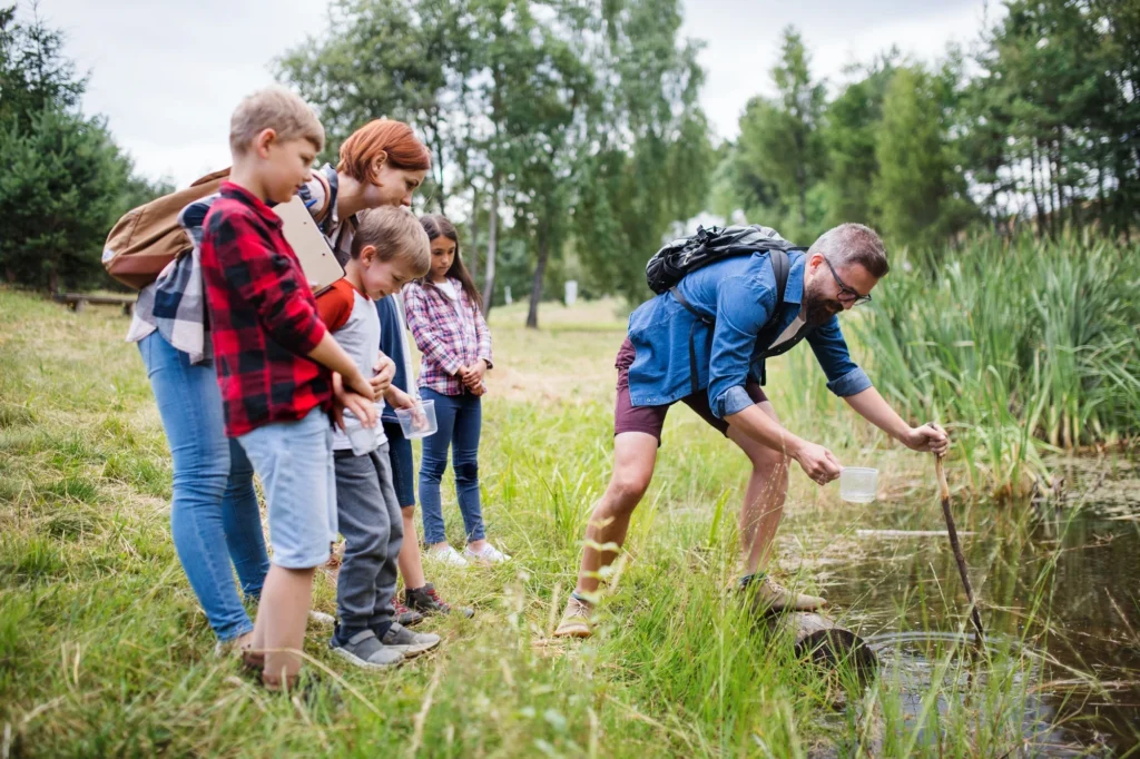 group of school children with teacher on field trip in nature 1