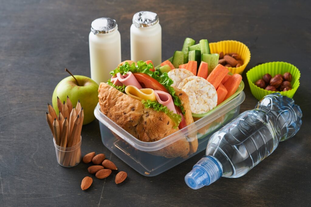Healthy food for school lunch concept. Healthy bread, meat sandwich with cheese, apple, fresh cucumb
