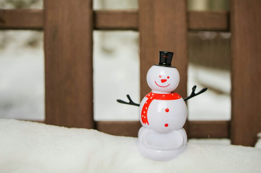 Snowman and christmas ball on snow