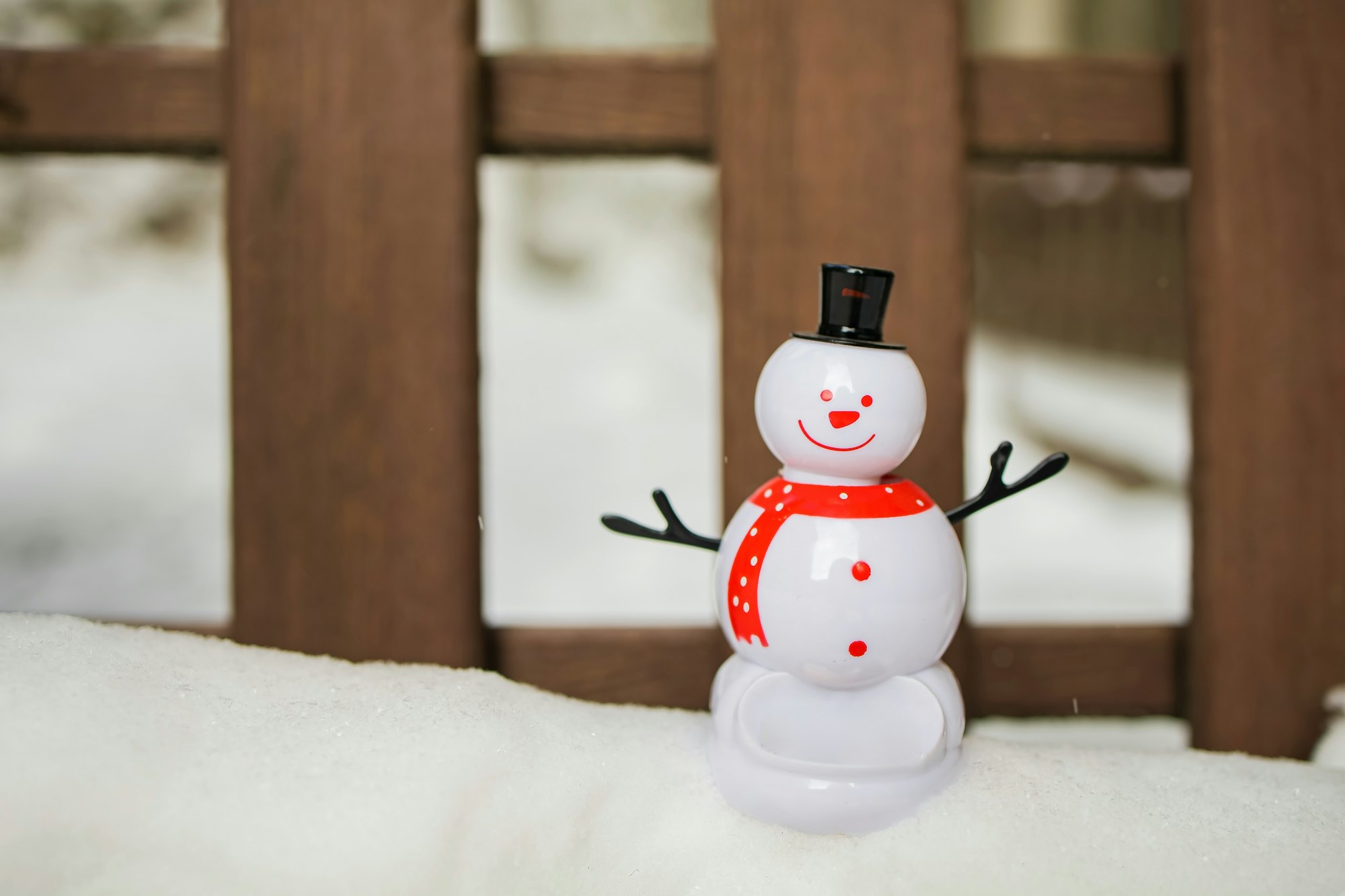 Snowman and christmas ball on snow