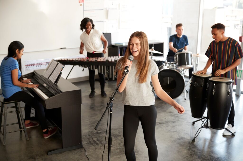 Students At Performing Arts School Playing In Band At Rehearsal