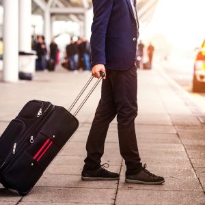 unrecognizable businessman with luggage at the airport entering Arrival Window